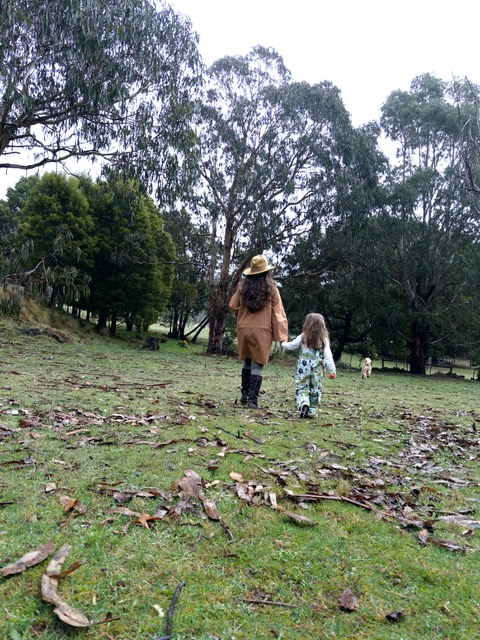 woman and young kid walking in the grass
